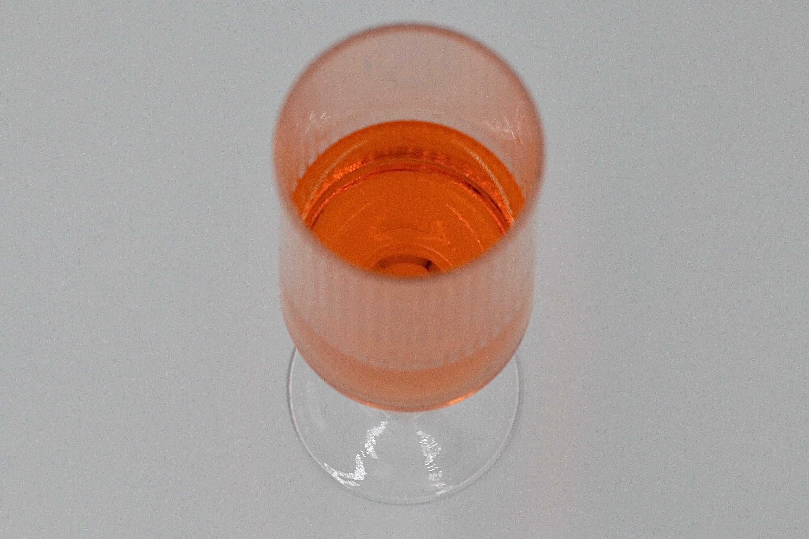Geriffeltes Sektglas mit oranger Flüssigkeit.