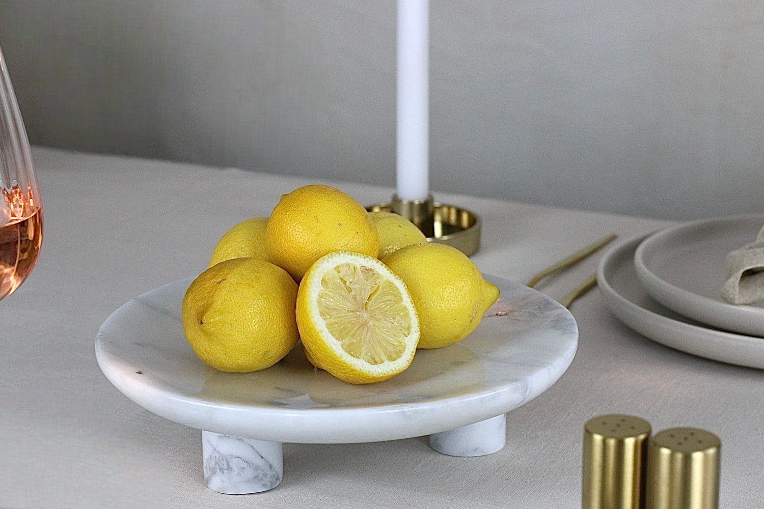 Marmorschale mit drei Füßen in Weiß und Grau, auf einem elegant gedeckten Tisch.