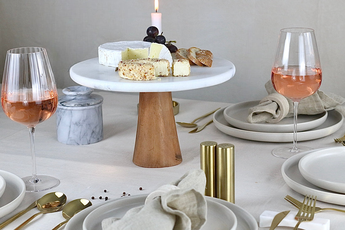 Kuchenplatte aus weißem Marmor mit Holzbeinen, auf einem elegant gedeckten Tisch.